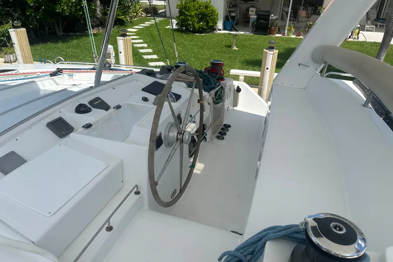 Slide: The Image of Steering area of a 2010 Lagoon 440 catamaran with visible controls and ropes. - 13