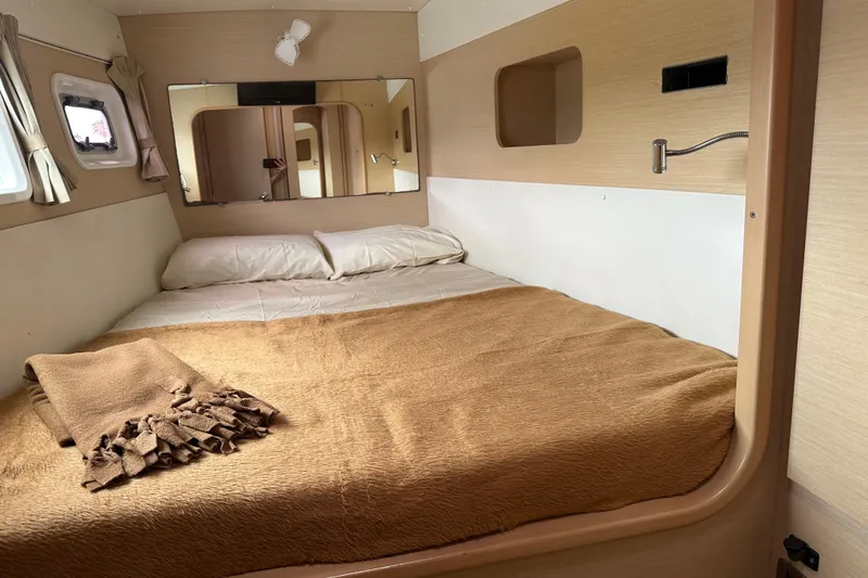Slide: The Image of Cozy cabin bedroom in 2010 Lagoon 440 catamaran with beige bedding and mirror. - 60