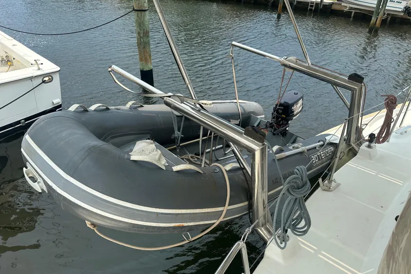 Slide: The Image of Inflatable dinghy with motor on Lagoon 440 catamaran, docked at marina, 2010 model. - 70