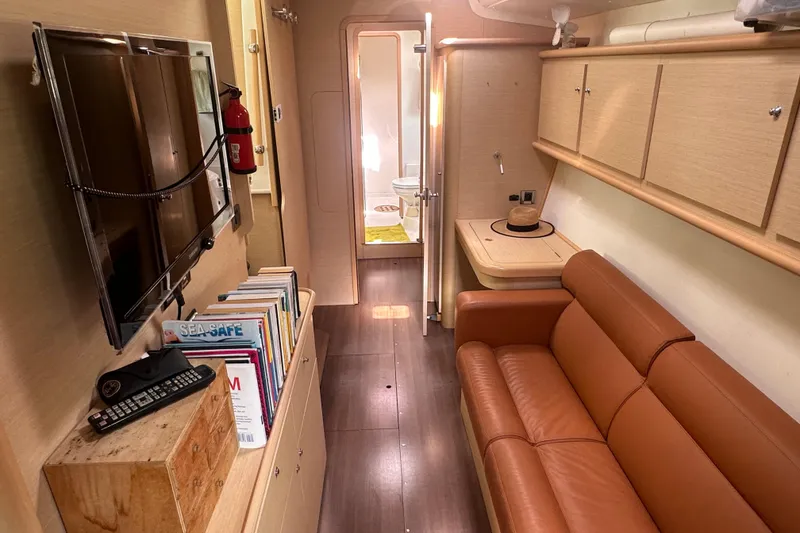 Slide: The Image of Interior of 2010 Lagoon 440 yacht with leather sofa, TV, and bookshelf. - 48