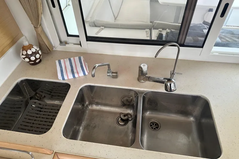 Slide: The Image of Modern kitchen sink setup on 2010 Lagoon 440 yacht, featuring dual basins and sleek faucets. - 42