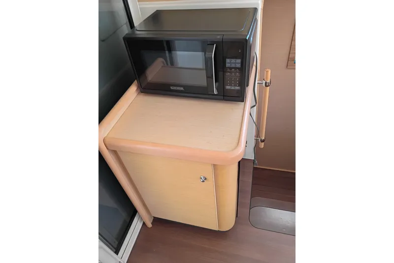 Slide: The Image of Microwave on wooden cabinet inside 2010 Lagoon 440 yacht interior. - 34