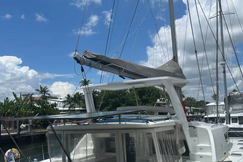 Slide: The Image of Lagoon 440 catamaran, 2010 model, docked under a clear blue sky with palm trees. - 73