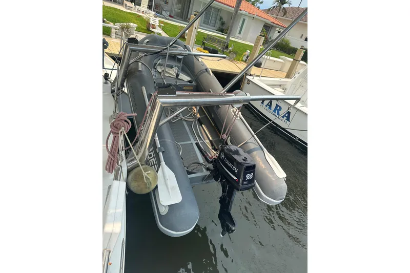 Slide: The Image of Inflatable boat with Tohatsu motor docked near Lagoon 440 catamaran, 2010 model. - 69