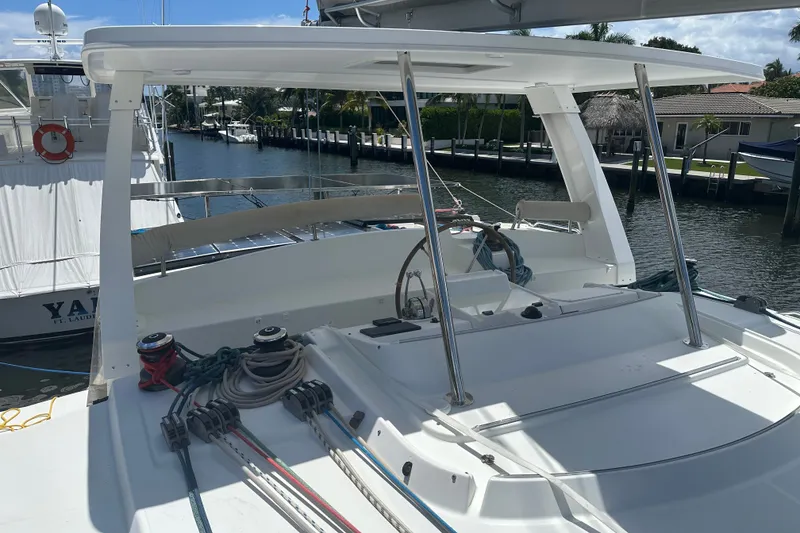 Slide: The Image of 2010 Lagoon 440 catamaran docked, featuring helm station and rigging equipment. - 79