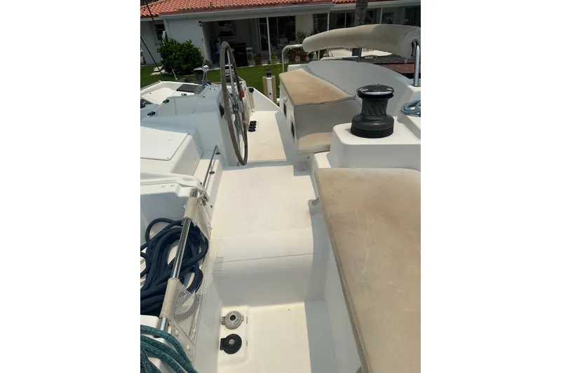 Slide: The Image of Cockpit of 2010 Lagoon 440 catamaran with steering wheel and seating area. - 14