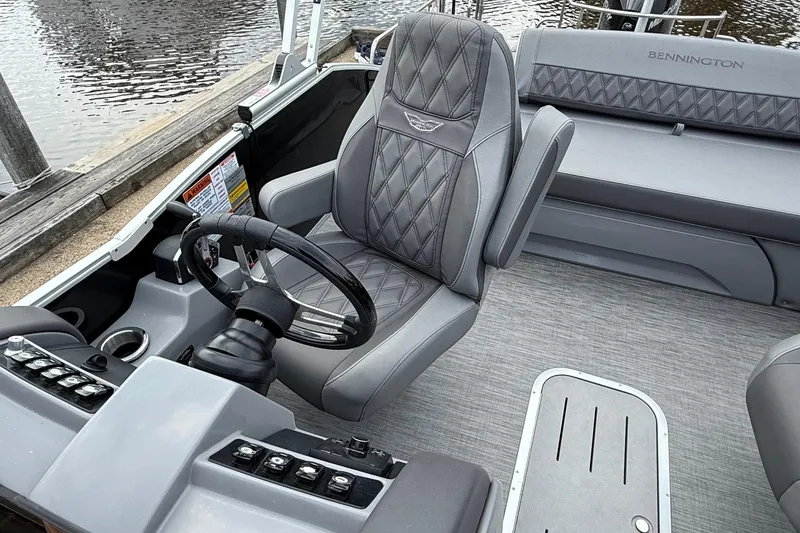Slide: The Image of 2023 Bennington 25RTSB boat interior with gray seating and steering wheel. - 13