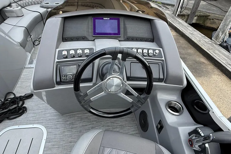 Slide: The Image of 2023 Bennington 25RTSB boat dashboard with steering wheel and control panel. - 11