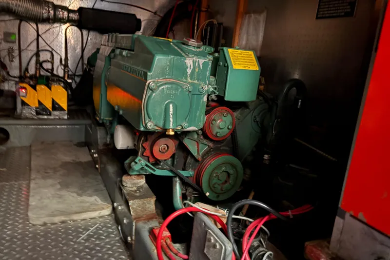 Slide: The Image of Engine room of a 1986 CHB Ponderosa boat, featuring a green marine engine. - 42