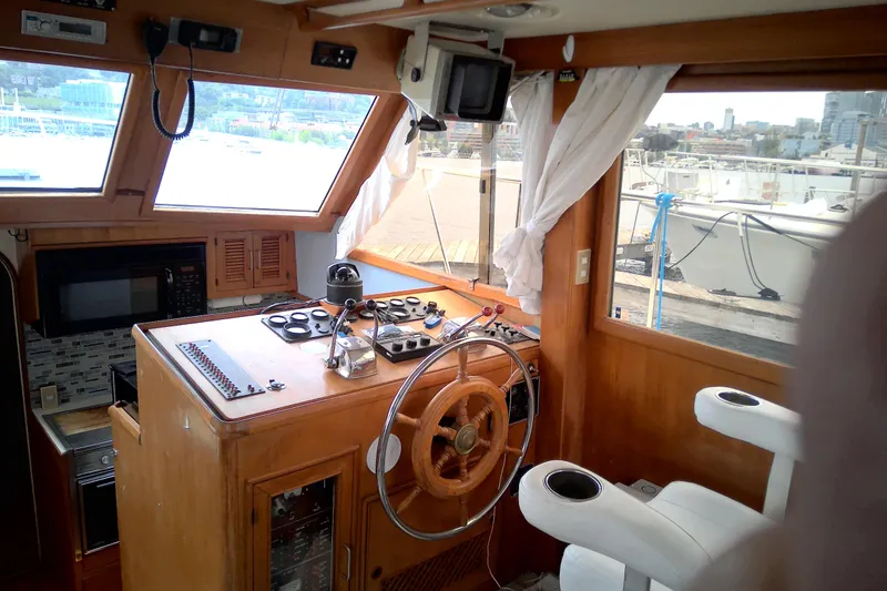 Slide: The Image of 1986 CHB Ponderosa boat helm with wooden steering wheel and navigation controls. - 22