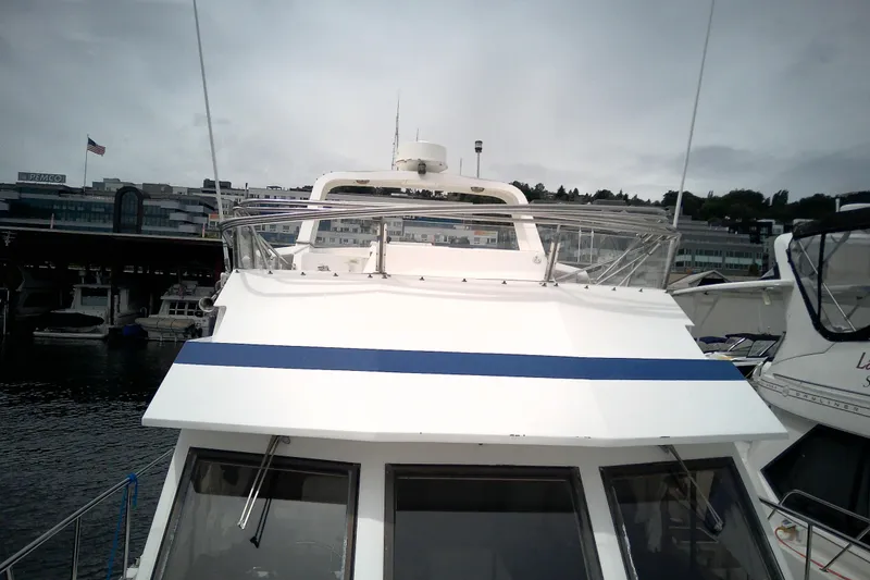 Slide: The Image of 1986 CHB Ponderosa yacht docked at marina, featuring sleek design and spacious deck. - 10