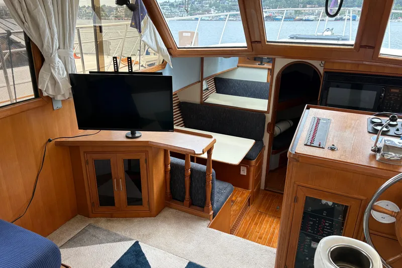 Slide: The Image of Interior of a 1986 CHB Ponderosa boat with TV, seating, and control panel. - 23