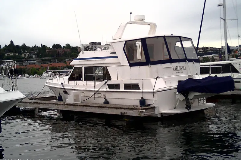 Slide: The Image of 1986 CHB Ponderosa yacht docked at marina, overcast sky, waterfront view. - 3