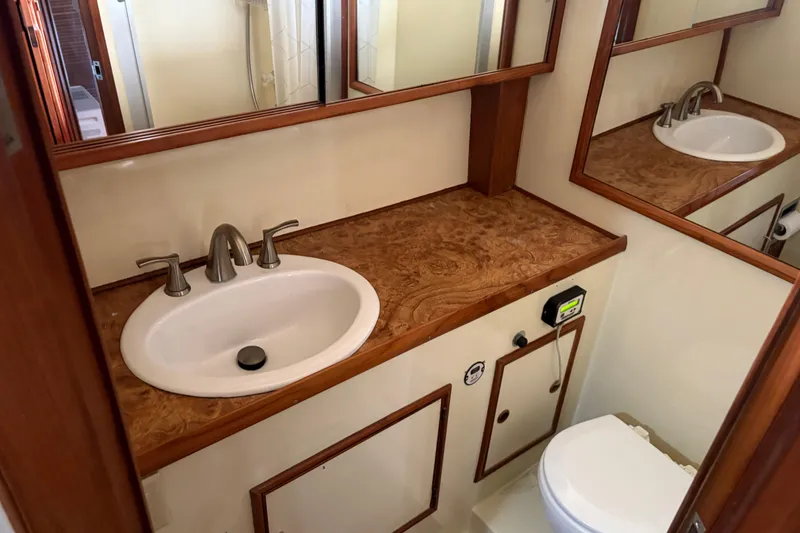 Slide: The Image of 1986 CHB Ponderosa yacht bathroom with wooden countertop, sink, and mirror. - 37