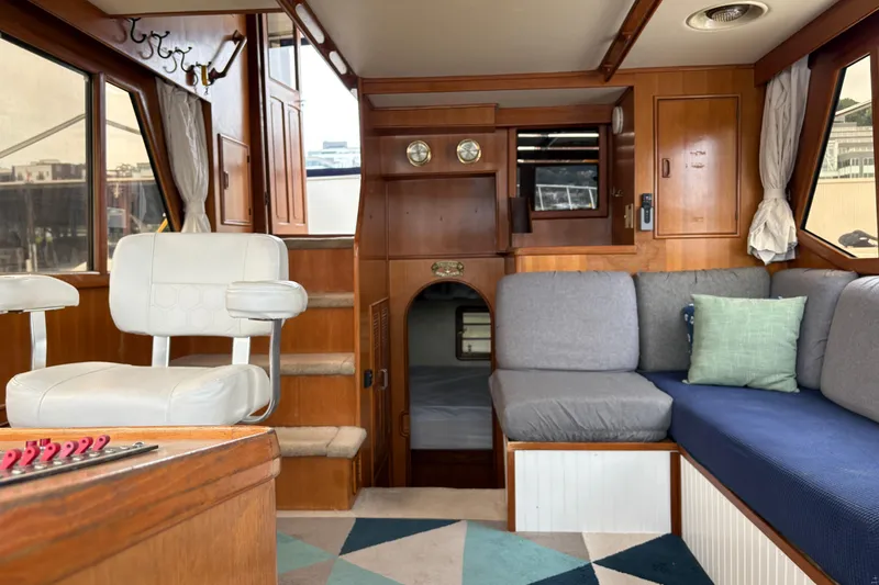 Slide: The Image of Interior of a 1986 CHB Ponderosa boat with cozy seating and wooden accents. - 26