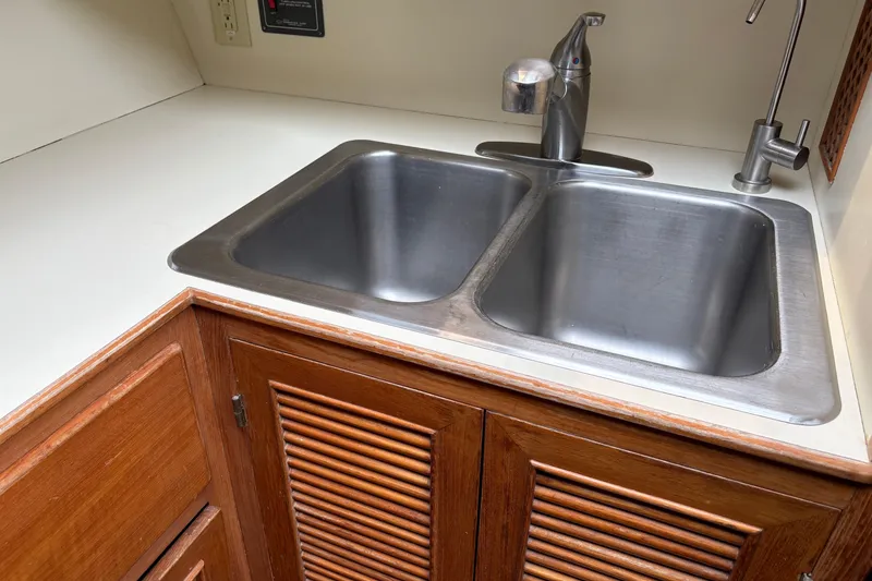 Slide: The Image of Stainless steel double sink in 1986 CHB Ponderosa boat kitchen with wooden cabinets. - 33