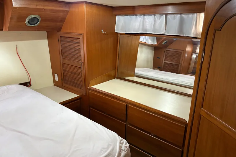Slide: The Image of 1986 CHB Ponderosa yacht interior with wooden cabinetry and mirrored dresser. - 35