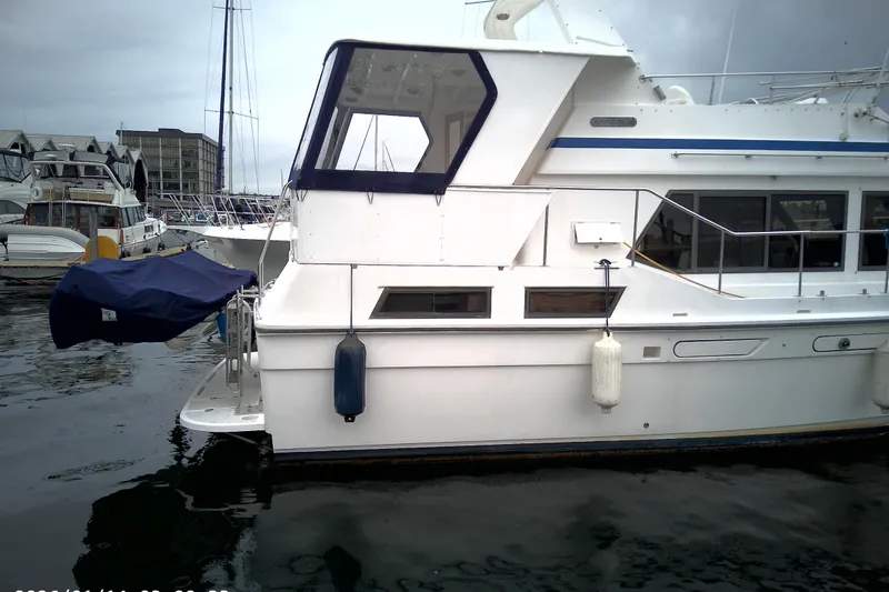 Slide: The Image of 1986 CHB Ponderosa yacht docked in a marina, featuring a white exterior and blue accents. - 4