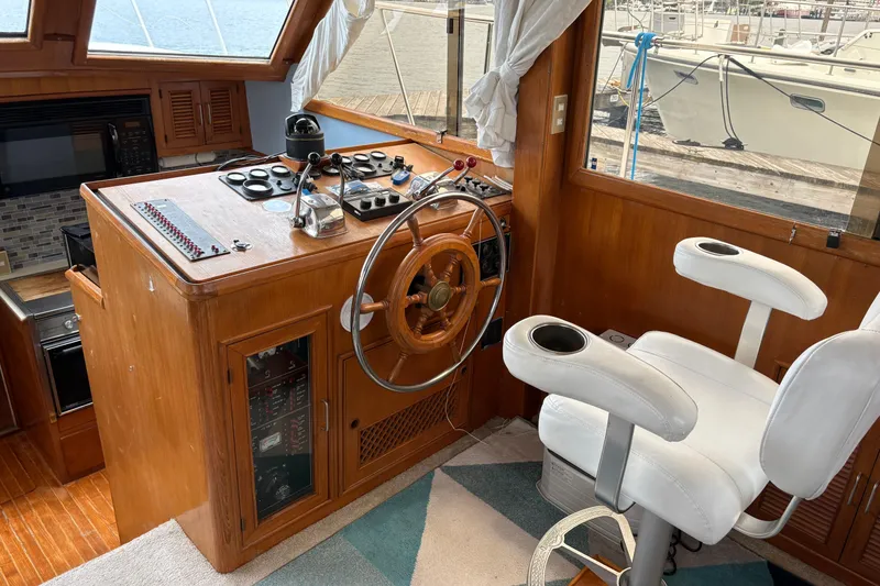 Slide: The Image of Helm of 1986 CHB Ponderosa boat with wooden steering wheel and white captain's chair. - 24