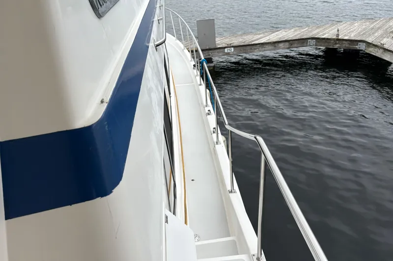 Slide: The Image of 1986 CHB Ponderosa boat docked by a wooden pier on calm water. - 7