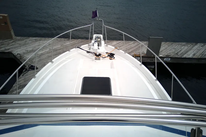Slide: The Image of 1986 CHB Ponderosa boat docked at a wooden pier, viewed from the bow. - 11