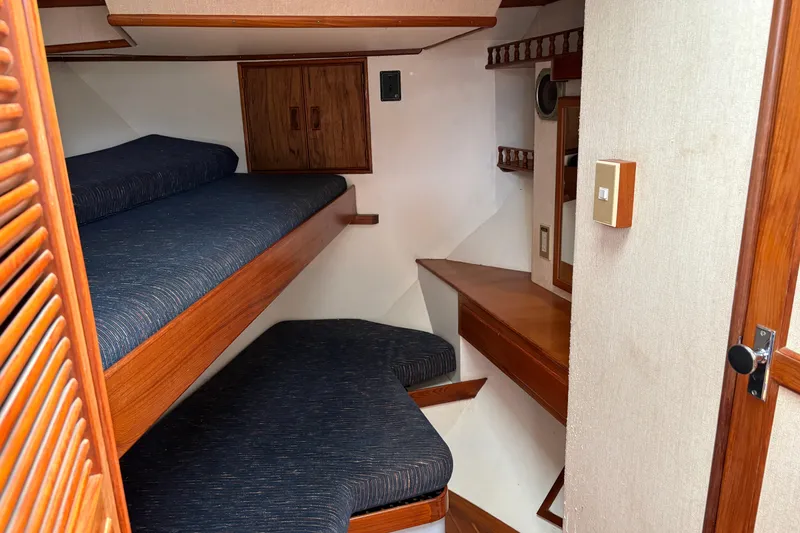 Slide: The Image of 1986 CHB Ponderosa cabin interior with wooden bunk beds and storage. - 28