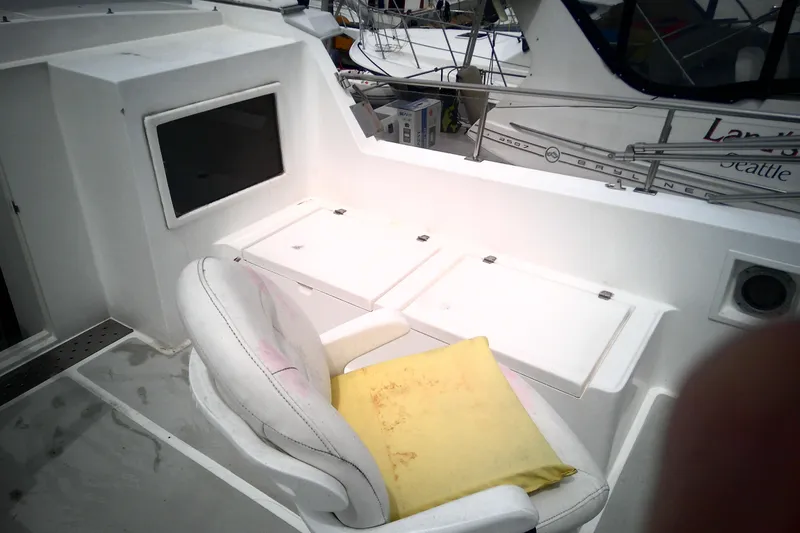 Slide: The Image of 1986 CHB Ponderosa boat interior with white seating and storage compartments. - 15