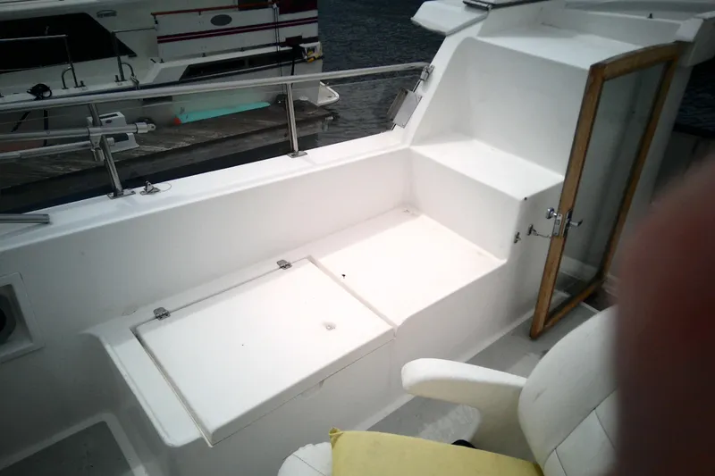Slide: The Image of 1986 CHB Ponderosa boat deck with seating and railing, docked near water. - 16