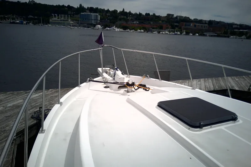 Slide: The Image of 1986 CHB Ponderosa yacht docked by a scenic waterfront with distant buildings. - 9