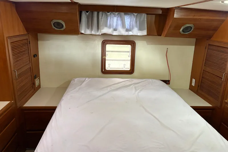 Slide: The Image of Interior cabin of a 1986 CHB Ponderosa boat with bed and wooden storage. - 34