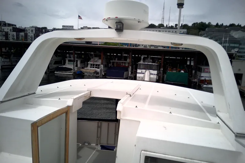 Slide: The Image of 1986 CHB Ponderosa boat docked at marina with cityscape background. - 17