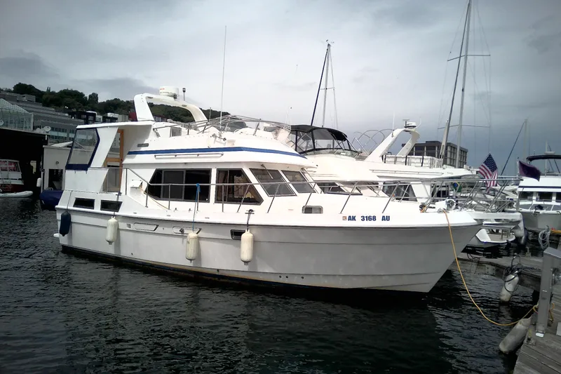 The Image of 1986 CHB Ponderosa yacht docked at marina, overcast sky, surrounded by other boats. - 1