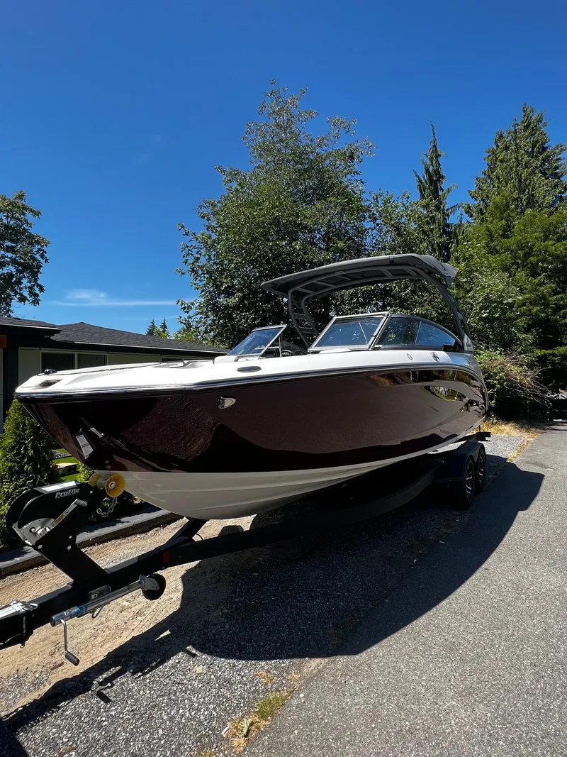 Slide: The Image of A 2022 Yamaha 252SE boat on a trailer, surrounded by trees and blue sky. - 12