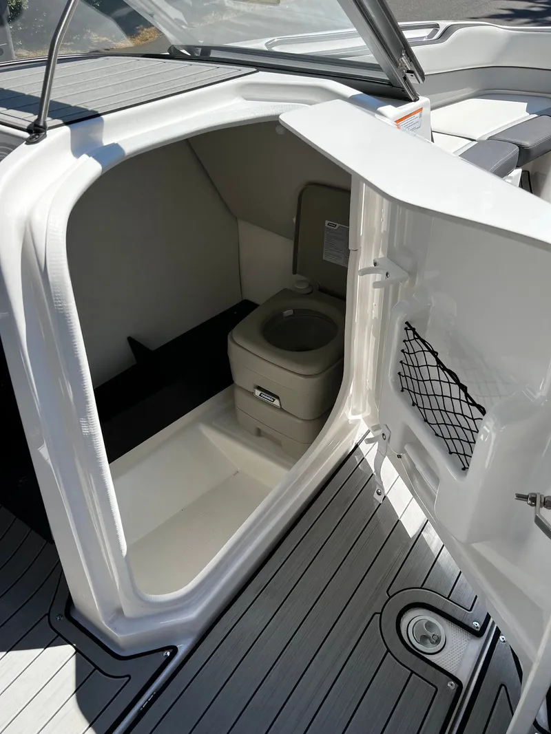 Slide: The Image of The image shows a toilet inside a modern boat with gray flooring. - 13