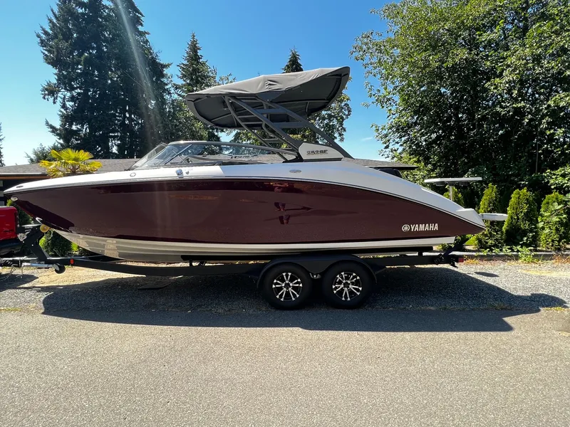The Image of 2022 Yamaha 252SE on a trailer, featuring a dark red hull and gray canopy. - 0
