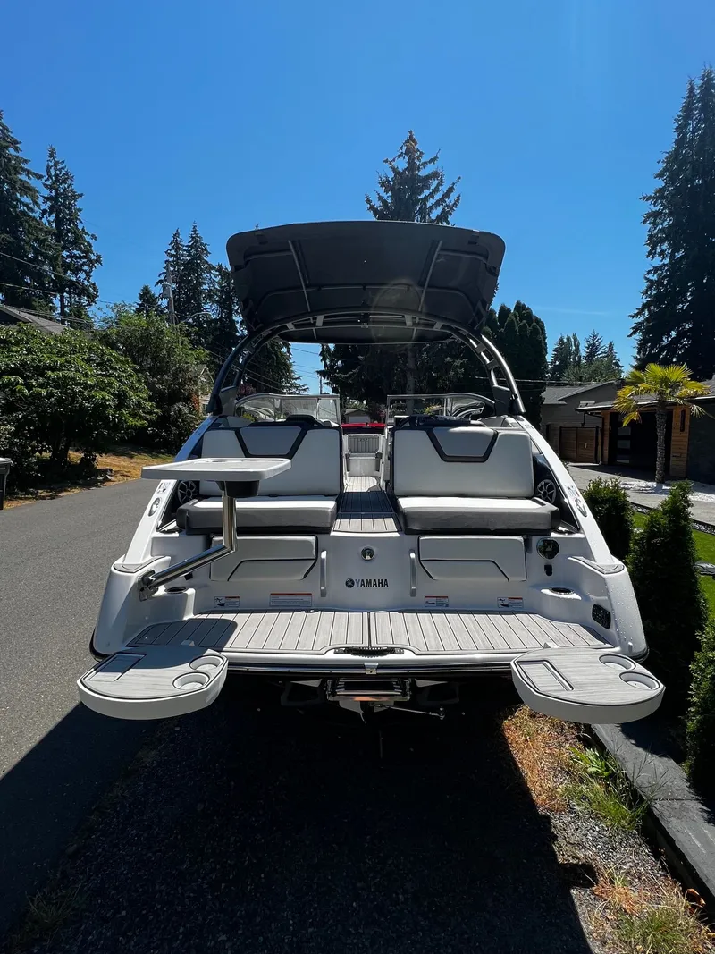 Slide: The Image of 2022 Yamaha 252SE with open deck and seating area, parked on a street. - 10