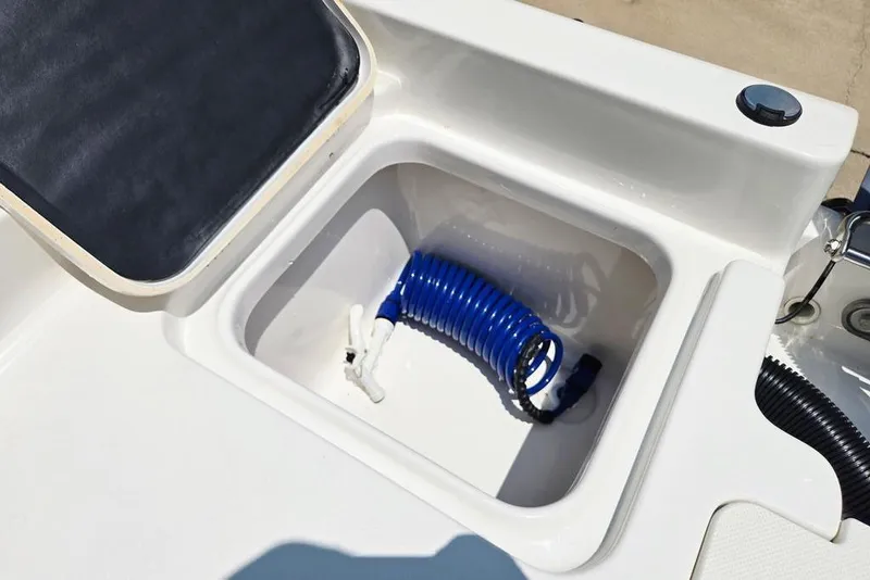 Slide: The Image of 2023 Key West 188 Bay Reef boat compartment with blue coiled hose. - 40