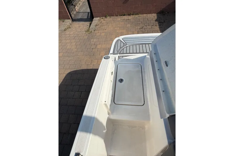 Slide: The Image of 2018 Bayliner VR5 Bowrider I/O boat deck, featuring a clean, white surface and storage compartment. - 12
