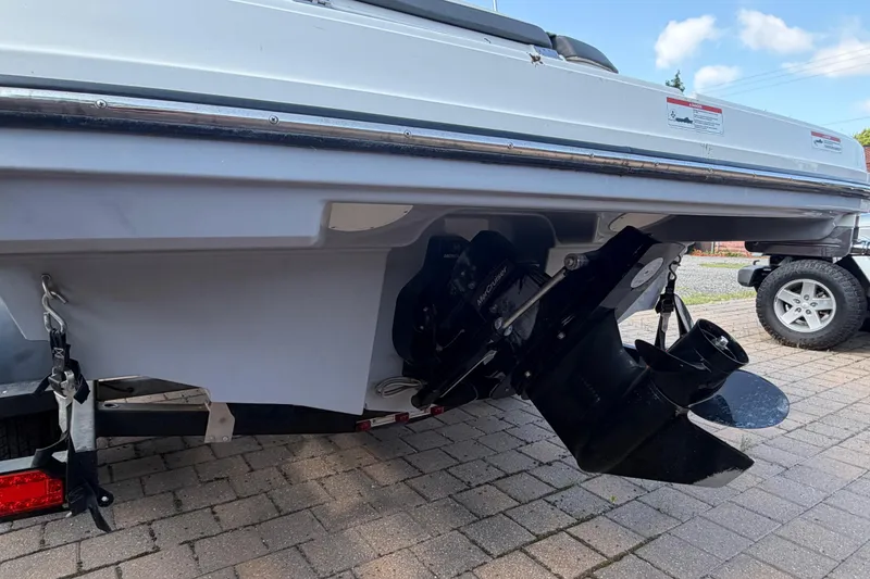 Slide: The Image of 2018 Bayliner VR5 Bowrider I/O boat stern with outboard motor on a paved driveway. - 8