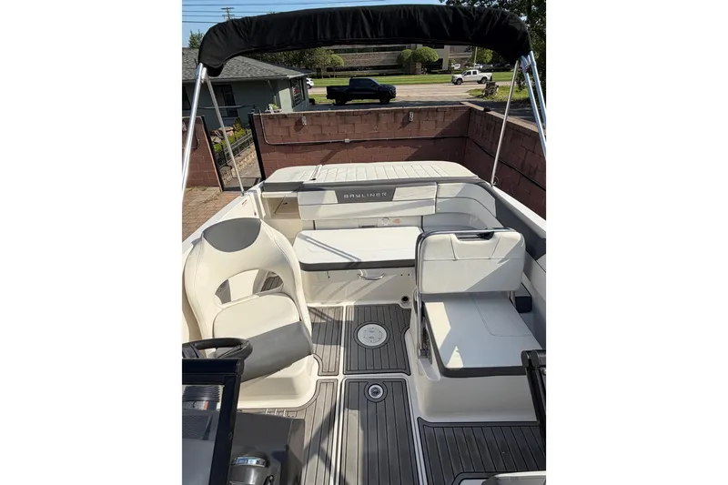 Slide: The Image of 2018 Bayliner VR5 Bowrider I/O interior with seating and steering wheel, docked outdoors. - 11