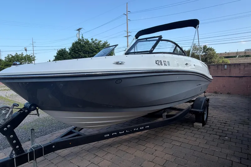 Slide: The Image of 2018 Bayliner VR5 Bowrider I/O boat on trailer, parked outdoors. - 2