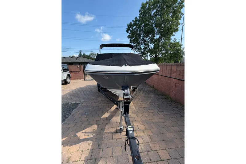 Slide: The Image of 2018 Bayliner VR5 Bowrider I/O on trailer, parked on brick driveway under clear sky. - 4