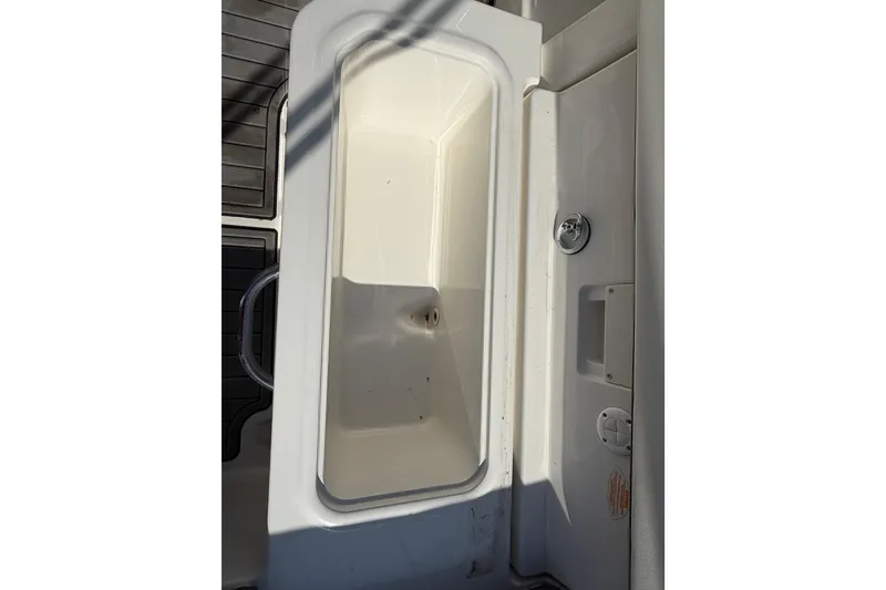 Slide: The Image of 2018 Bayliner VR5 Bowrider I/O storage compartment with white interior and handle. - 16