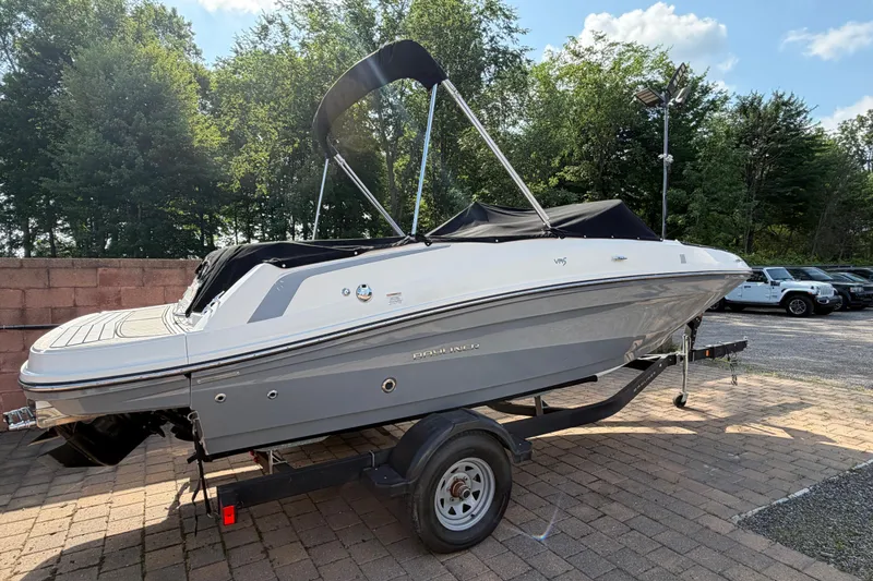Slide: The Image of 2018 Bayliner VR5 Bowrider I/O on trailer, parked outdoors with trees in background. - 6