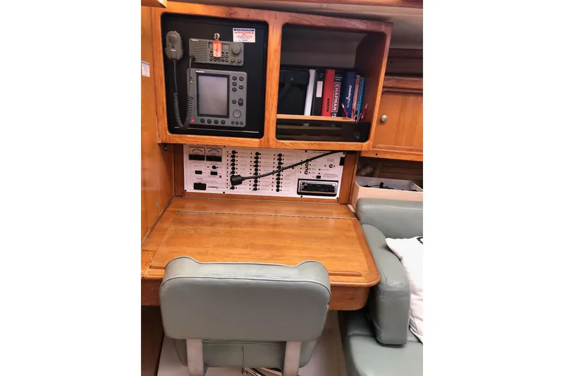 Slide: The Image of Navigation station inside a 1999 Catalina 400 yacht with communication equipment and books. - 6
