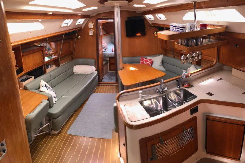 Slide: The Image of Interior of a 1999 Catalina 400 sailboat with cozy seating and a compact kitchen. - 3