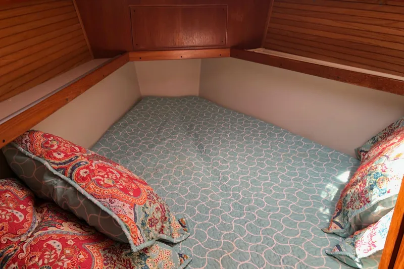 Slide: The Image of Cozy cabin bed in a 1999 Catalina 400 sailboat with colorful bedding. - 10