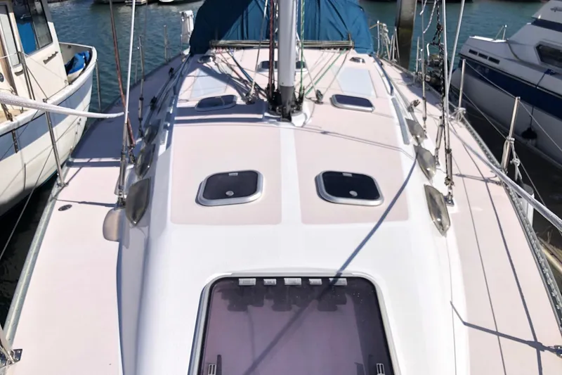 Slide: The Image of 1999 Catalina 400 sailboat deck view, docked in a marina, showcasing hatches and rigging. - 14