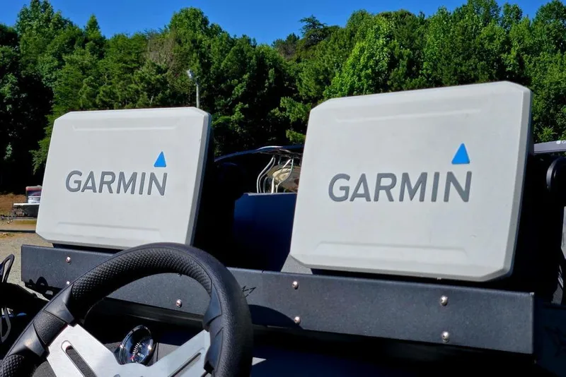 Slide: The Image of 2022 Vexus AVX1980 boat with dual Garmin displays, steering wheel, and lush green background. - 51