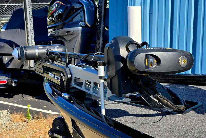Slide: The Image of 2022 Vexus AVX1980 boat with Minn Kota Ultrex trolling motor, parked near a blue building. - 11